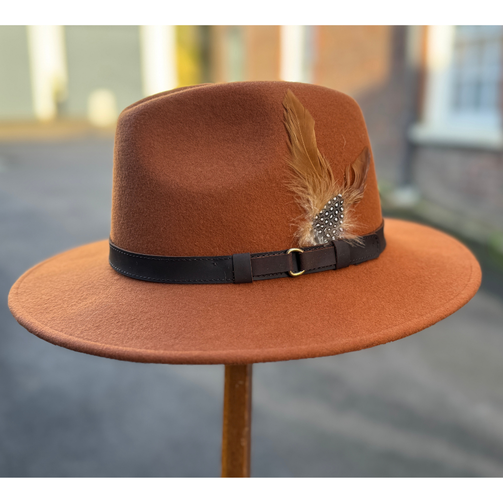 Rust fedora hat with a feather from Sussex Hats, Arundel